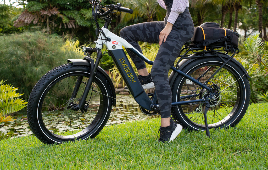 Rider using IMREN electric bike on grass path for everyday outdoor riding
